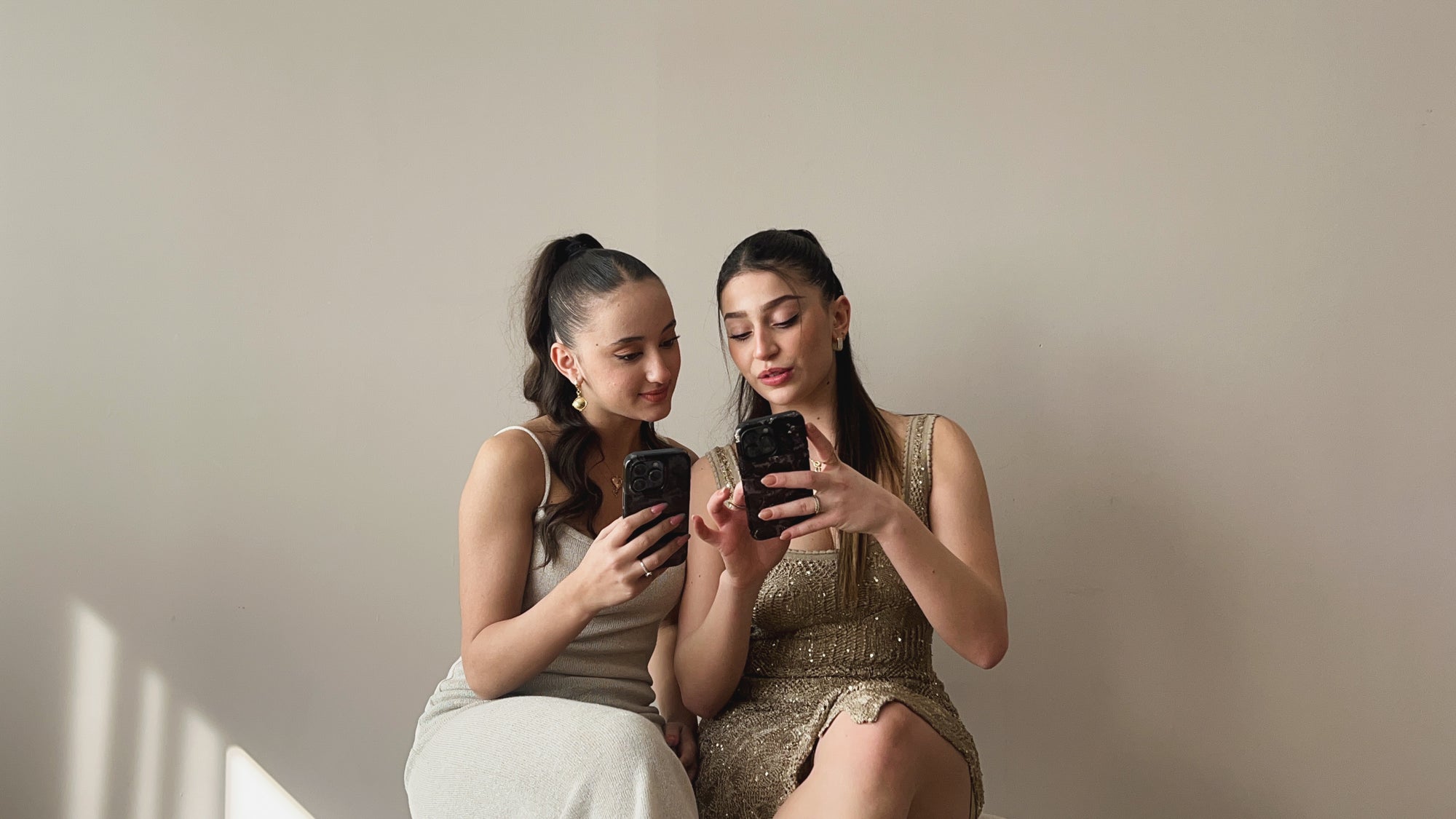 Blog News image featuring two girls holding phones with designed dalge phone cases talking and smiling.